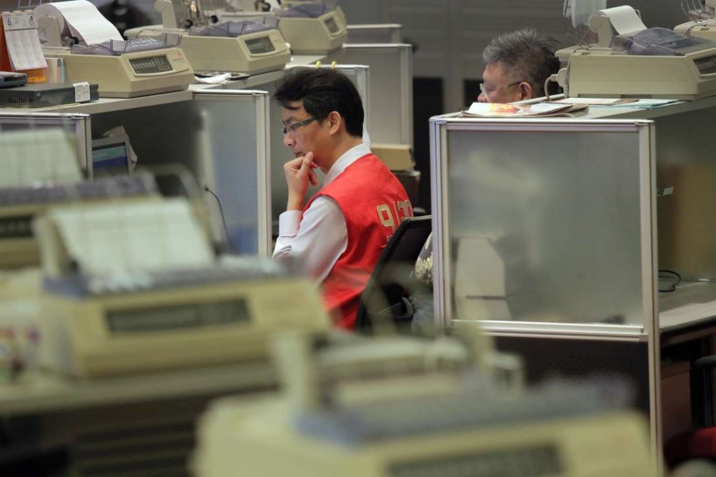 A trader at the Hong Kong Stock Exchange. The Hang Seng Index set a record high for 2016, reaching 22,000.49 points. Market turnover hit a weekly high of HK$65.28 billion. Photo: AP