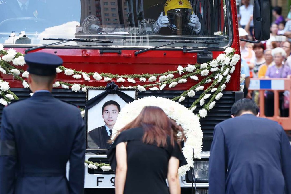 The funeral service for late fireman Samuel Hui went past the the scene of the fire at Amoycan Industrial Centre in Ngau Tau Kok. Photo: K. Y. Cheng