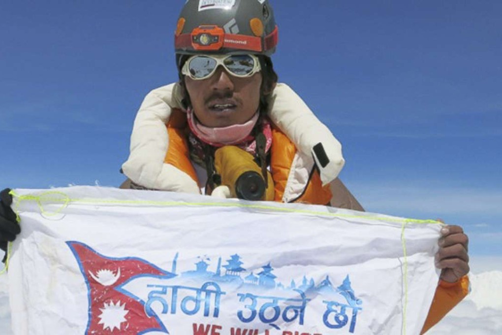 Phurba Tenzing Sherpa unfurls the flag of the We Will Rise foundation at the summit of Mount Everest in May 2016. Photo: Phurba Tenzing Sherpa