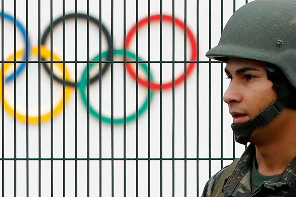 A Brazilian military police soldier patrols at the security fence outside the 2016 Rio Olympics Park in Rio de Janeiro, Brazil. Photo: Reuters