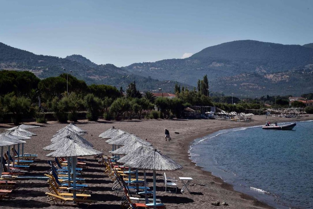 A man walks on an empty beach in the resort of Petra on Lesbos. Photo: AFP