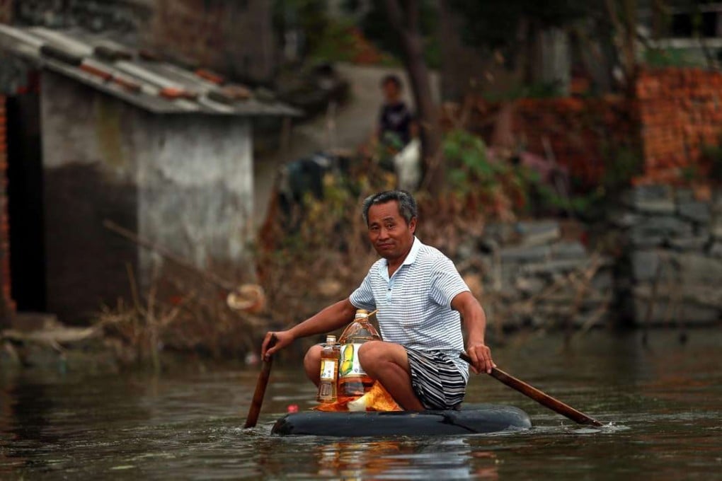 A man paddles in a makeshift boat on floodwater, in Xinchang county, in Hubei province, last week. Photo: EPA