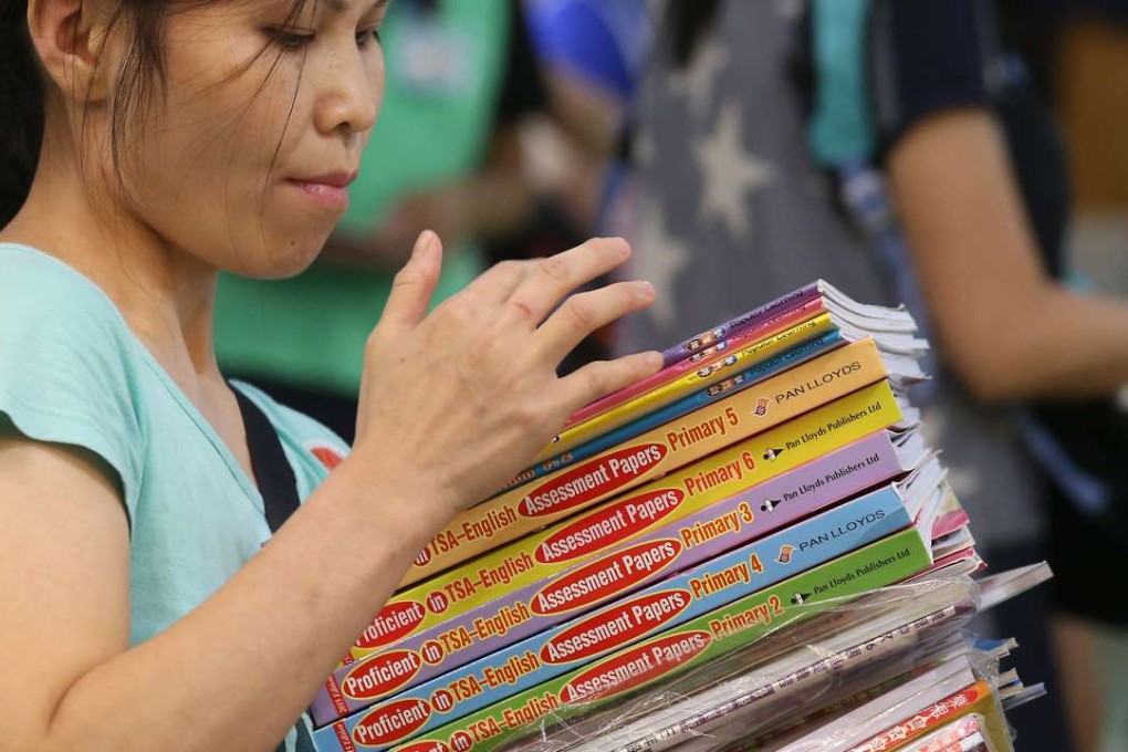 A woman holds exercise books on the first day of the 2016 Hong Kong Book Fair at the Convention and Exhibition Centre in Wan Chai. Photo: K. Y. Cheng