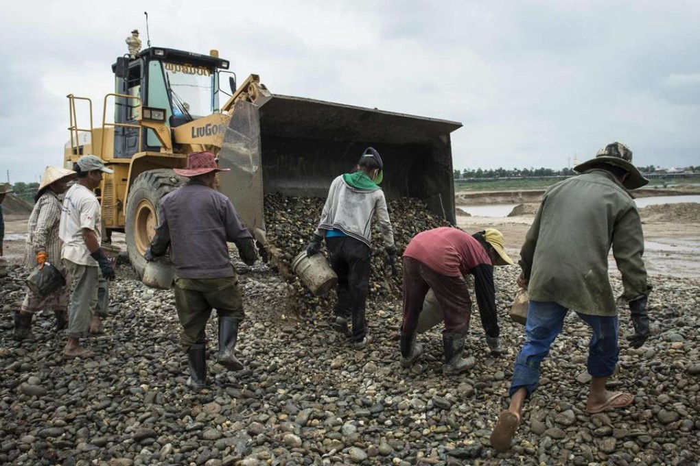Workers gather pebbles at a sand excavation site along the Mekong River in Vientiane. Photo: AFP
