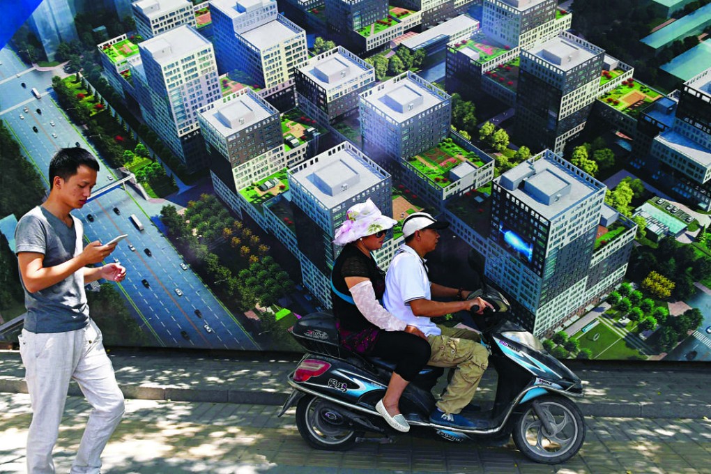 People pass by a billboard advertisement for a commercial and residential complex in Beijing. Photo: AFP