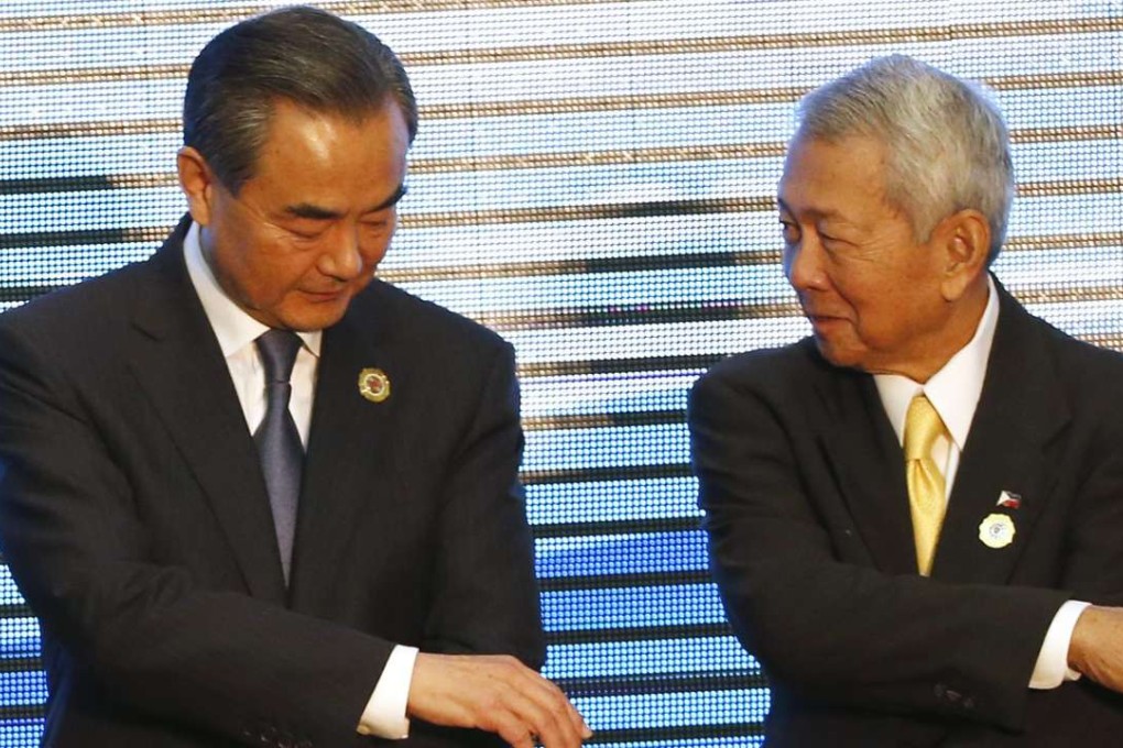Foreign Minister Wang Yi, left, reaches his hand to Philippines' Foreign Affairs Secretary Perfecto Yasay in Vientiane on Tuesday. Photo: EPA