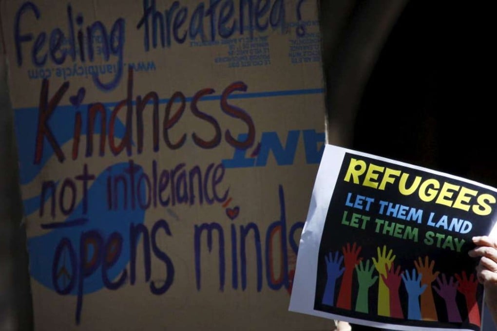 Protesters hold placards at the ‘Stand up for Refugees’ rally held in central Sydney, in this October 11, 2014. Photo: Reuters