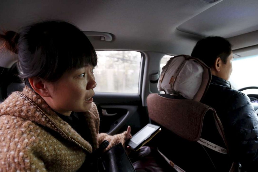 New regulations set to come into effect on November 1st clear a legal pathway for online ride-sharing companies in China without having to formally register as taxis. A passenger instructs an Uber driver en route to her office in Beijing on November 18, 2015. Photo: Reuters