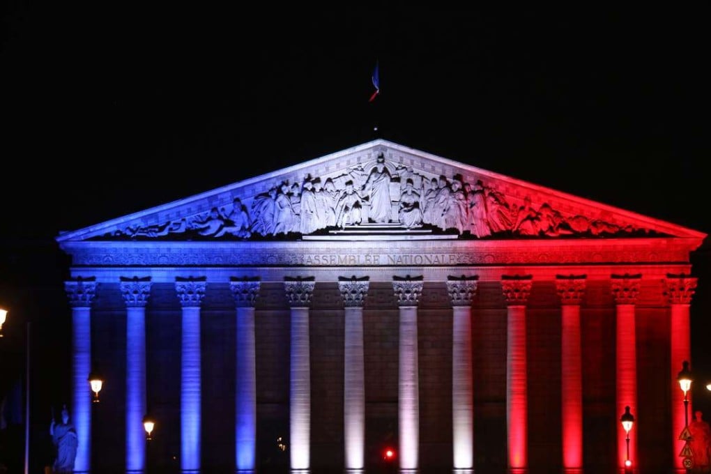 The French National Assembly's palais Bourbon in Paris illuminated in the French flag colours in tribute to the victims of the attack in the Normandy city of Saint-Etienne-du-Rouvray. Photo: AFP