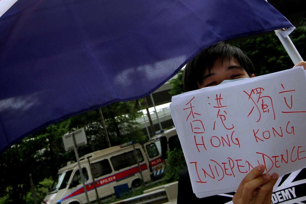 A member of "We are Hongkongers, Not Chinese" waves the colonial Hong Kong flag outside the central government's liason office in Western district on October 1, 2012. Picture: Dickson Lee