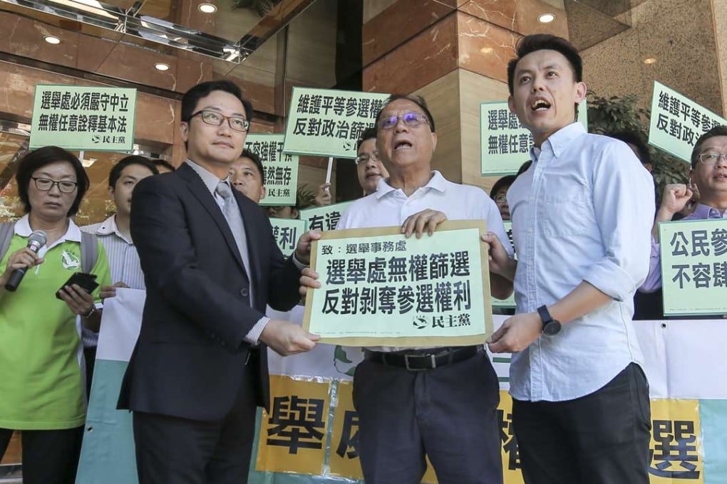 Members of Democratic Party shout slogans outside the Registration and Electoral Office to protest against the requirement for candidates to sign a form accepting that Hong Kong is a part of China. Photo: Paul Yeung