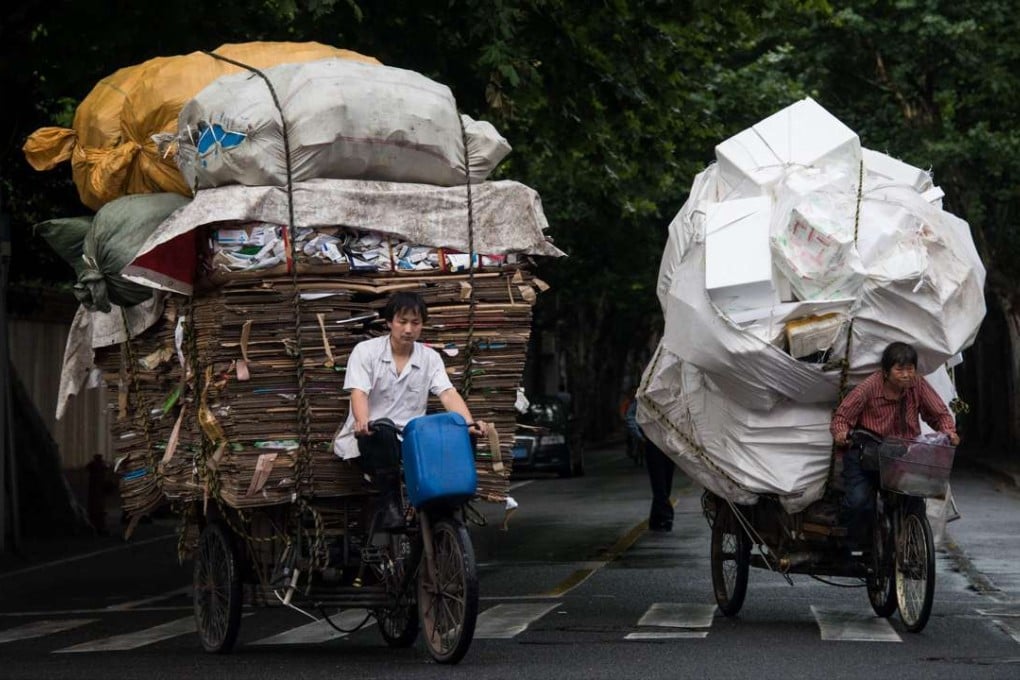 Waste collectors ride their loaded tricycles on the streets in Shanghai. Economic activity in China has stabilised in recent months. Photo: AFP
