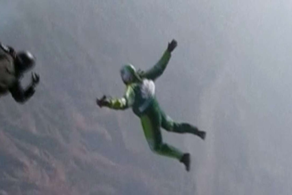 In this image made from a video provided by Mondelez International, Luke Aikins, (in green), skydives without a parachute over Simi Valley, California. Photo: AP