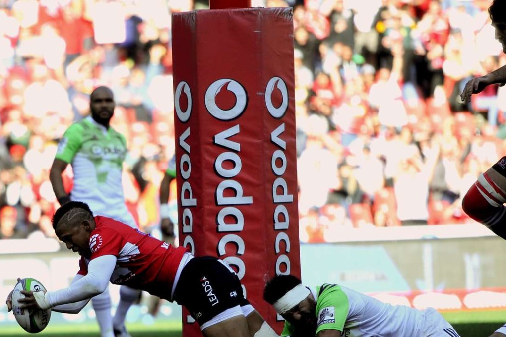 Golden Lions fly-half Elton Jantjies scores a try while being tackled by Ash Dixon of the Highlanders during their Super Rugby semi-final at Ellis Park in Johannesburg on Saturday. Photo: AFP