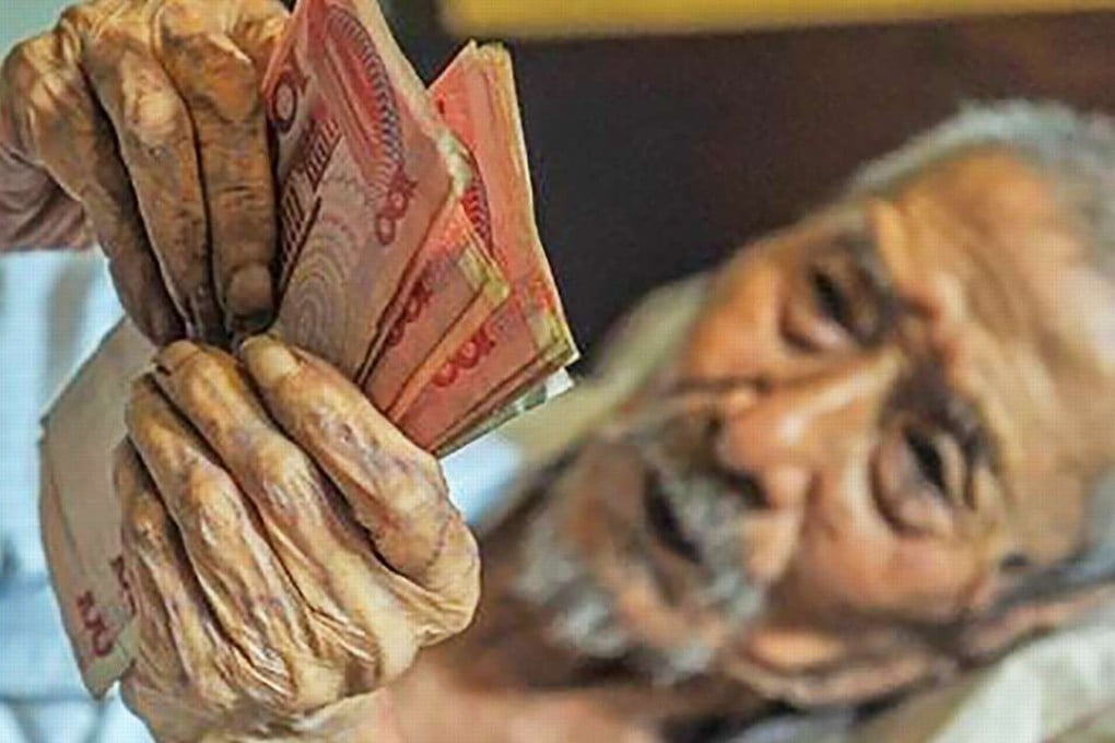 Former bank teller Lin Yongqing, 103, who spends most of his time in bed at his home in Sichuan province, still enjoys counting money every day. Photo: SCMP Pictures