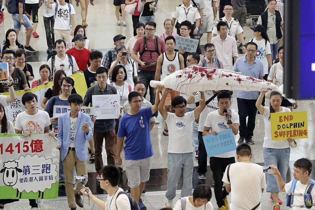 Members of the Airport Development Concern Network hold a mock dolphin in protest. Photo: Paul Yeung
