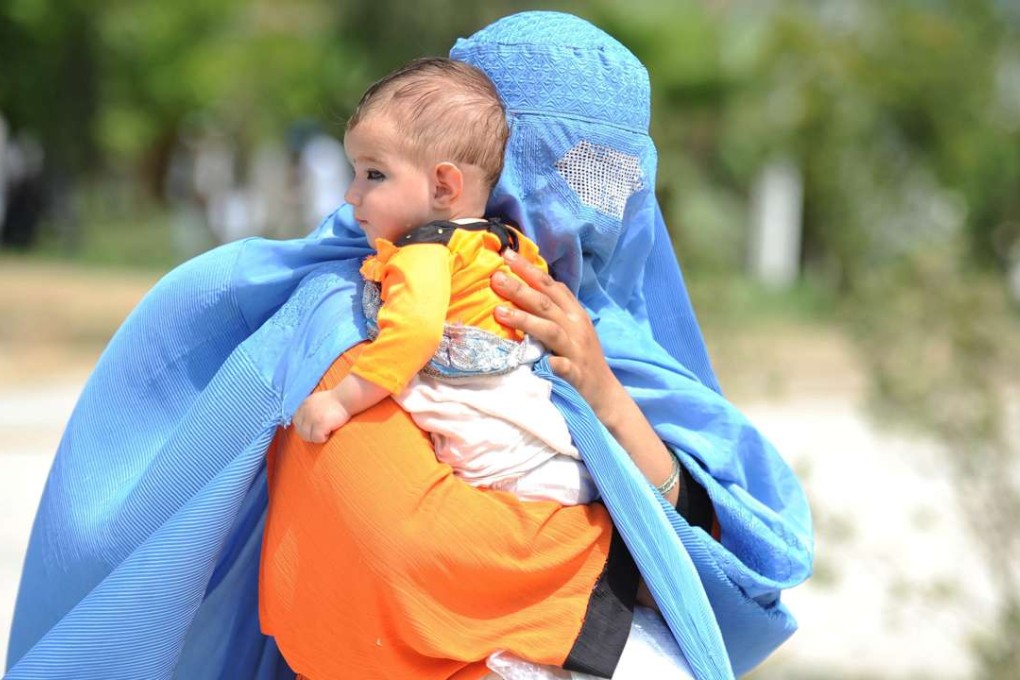 A burqa-clad Afghan refugee arrives with her child at a United Nations High Commissioner for Refugees (UNHCR) camp in Behshood district of Nangarhar province, Afghanistan. Photo: EPA