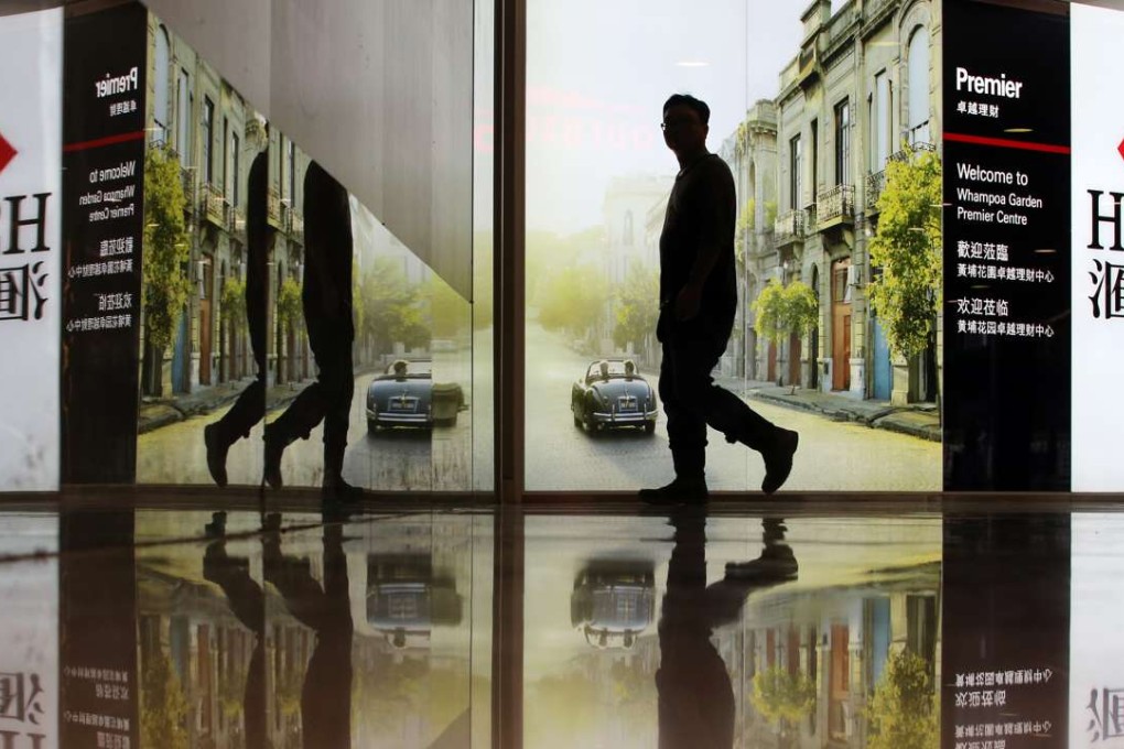 A passer-by passes HSBC advertising board in Hung Hom. Photo: Felix Wong