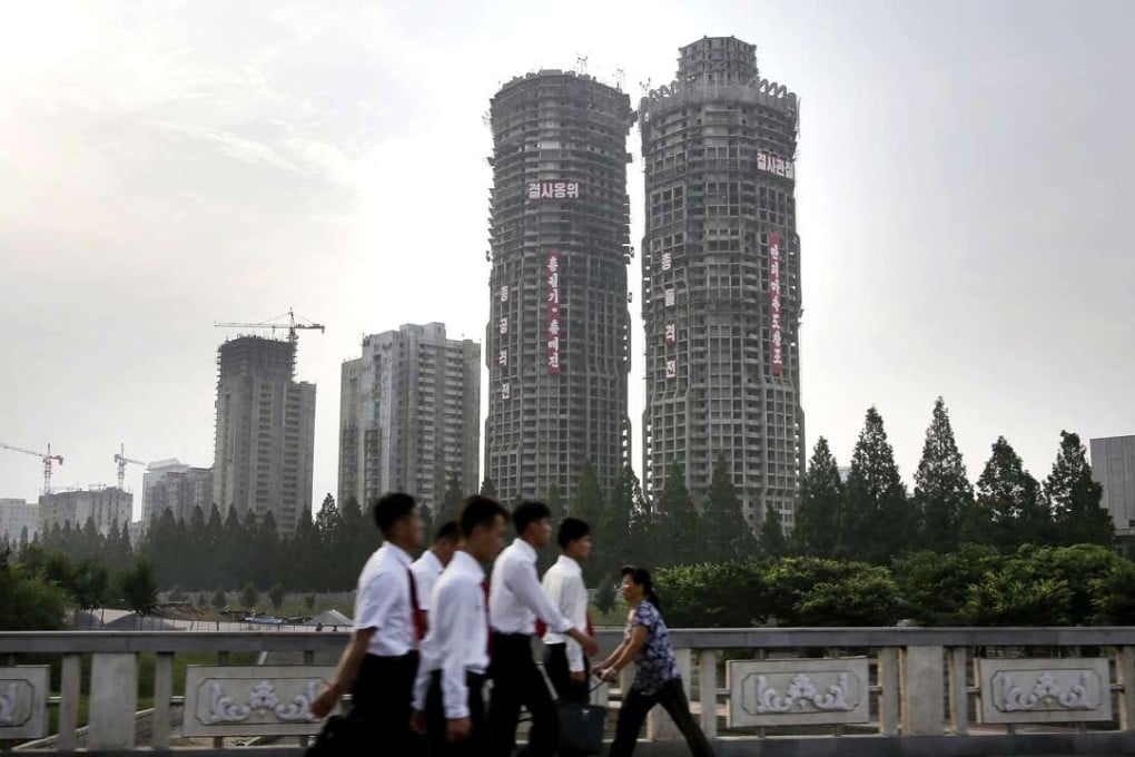 North Koreans walk past buildings under construction on ‘Ryomyong Street’, in Pyongyang. North Korean leader Kim Jong-un hopes to show the world his country is doing just fine despite sanctions and outside pressure over its nuclear weapons program. Photo: AP