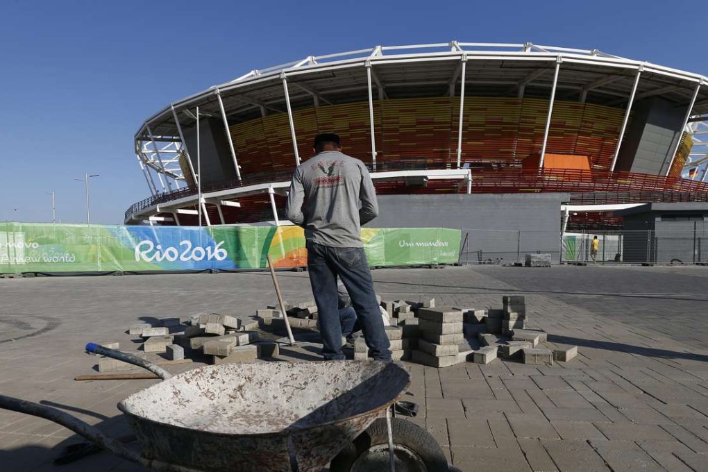 Finishing touches – workers lay bricks in the walkway inside the Olympic village grounds in Rio de Janeiro. Photo: EPA