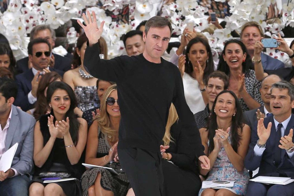 Raf Simons waves after presenting his autumn-winter haute couture 2014/15 collection for Christian Dior. Photo: EPA