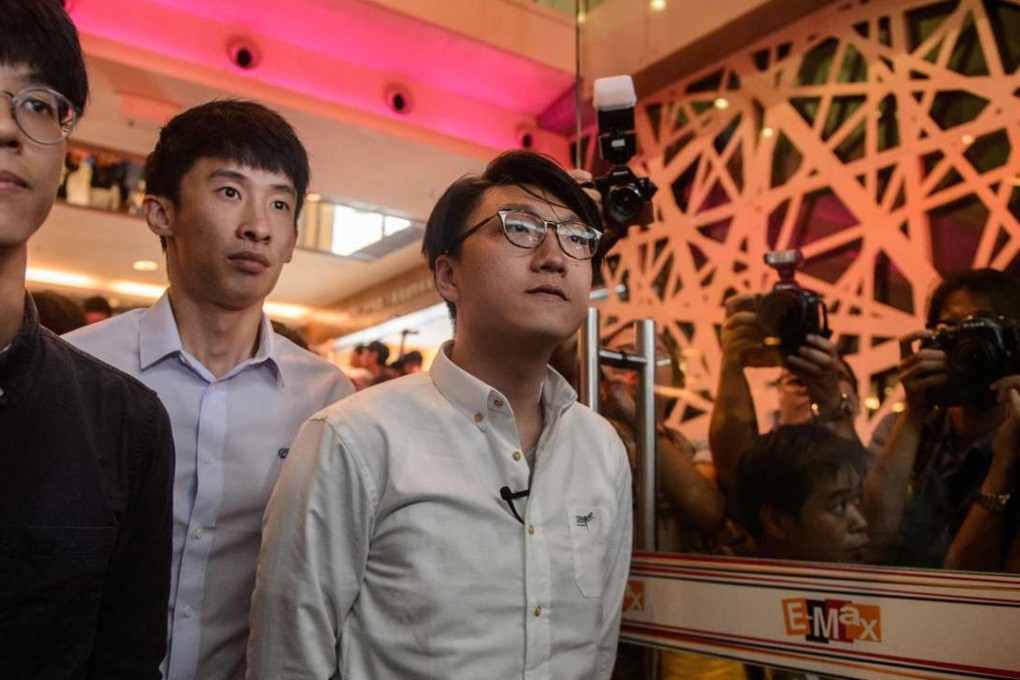 Signing the declaration form did not prevent Edward Leung (right) from being disqualified from standing in the Legco election. Photo: AFP