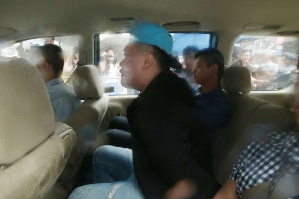 The suspect (wearing a cap) en route to police headquarters in Wan Chai on Wednesday. Photo: David Wong