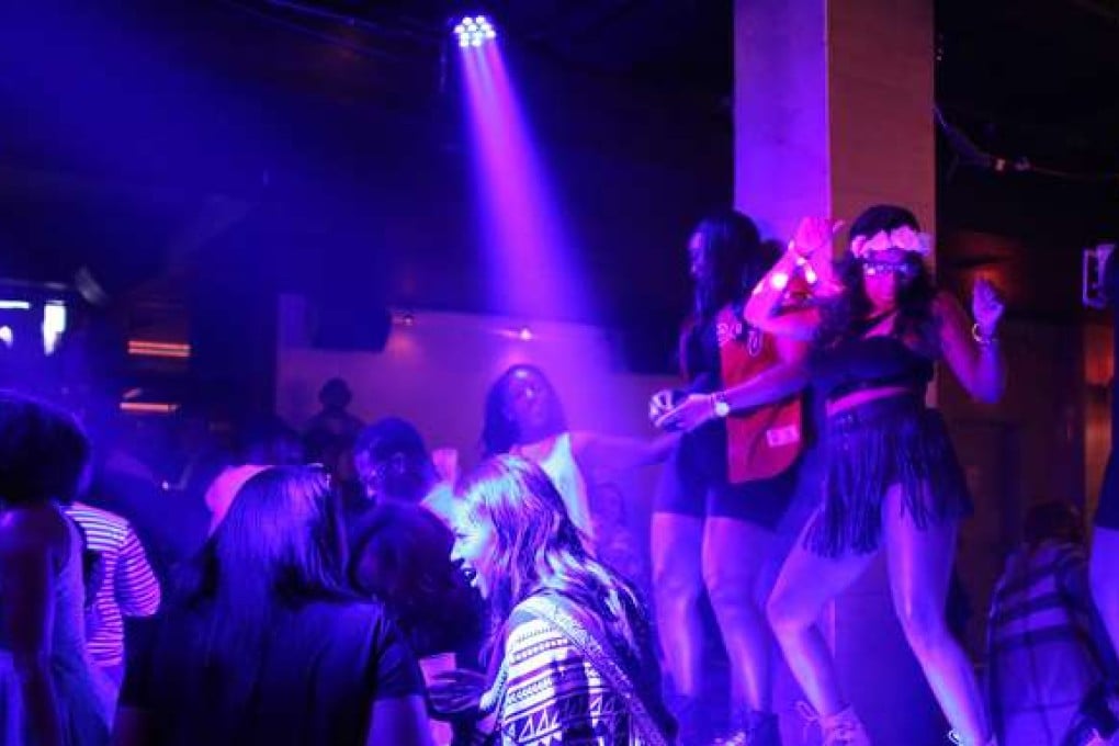 Black millennials, including Paris Mcfarland, at right with flowers, dance during a day party hosted by the Civilized Empire collective on June 18, 2016, at the LITE Chicago nightclub in the River North neighborhood of Chicago. (Anthony Souffle/Chicago Tribune/TNS)