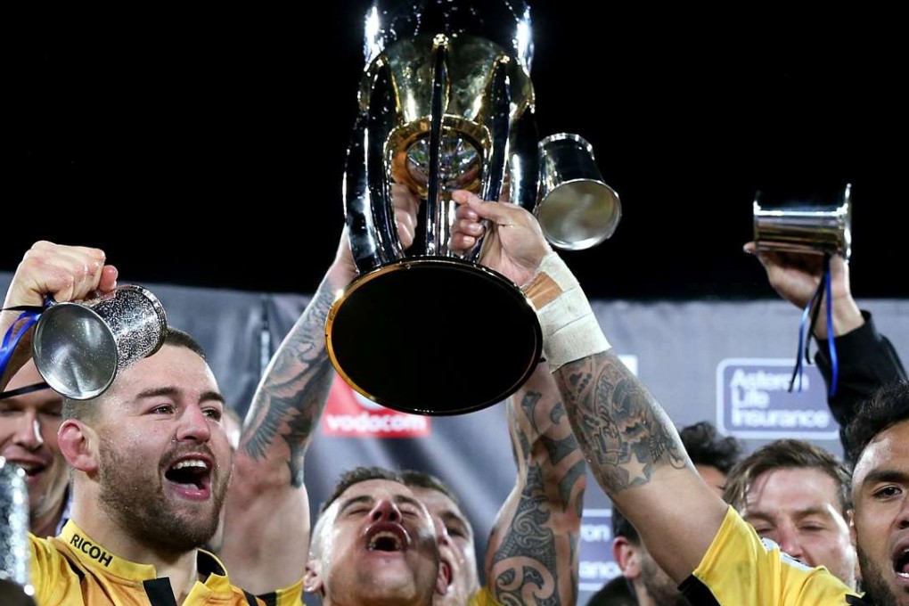 Captain Dane Coles (left) and Hurricanes teammates celebrate with the trophy after winning the Super Rugby final against the Golden Lions. Photo: AFP