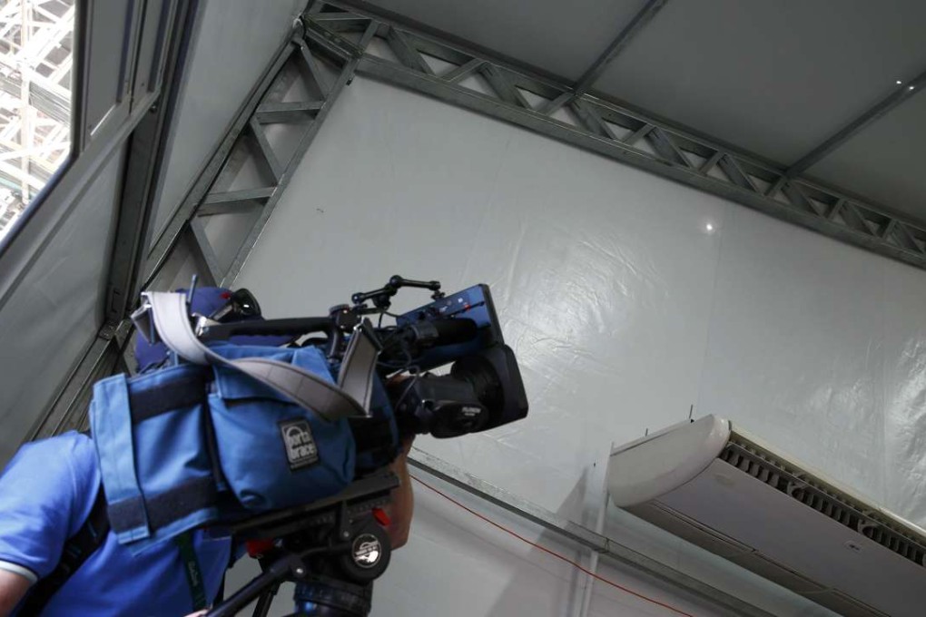 A television cameraman films the two holes in the media tent at the Deodoro Olympic Equestrian Centre. Photo: Reuters