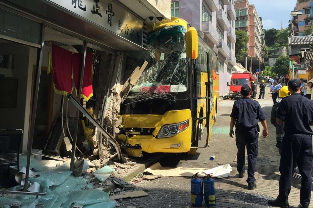 Officers check the tourist bus that crashed into a Chinese medicine shop in Macau. Photo: Xinhua