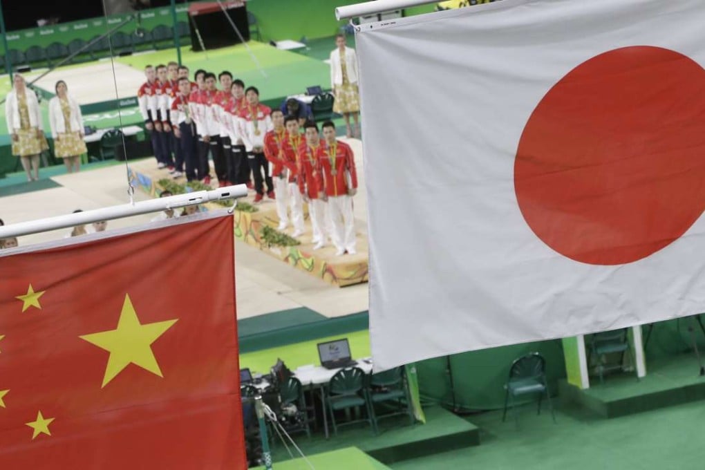 Double pain: an incorrect version of the Chinese national flag is hoisted below the Japanese banner after Japan took the gymnastics team gold. Photo: AP