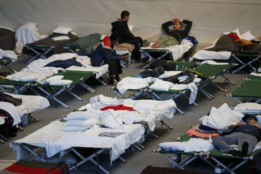 Refugees and migrants rest at a shelter in a sports hall in Hanau, Germany, last October. Photo: Reuters