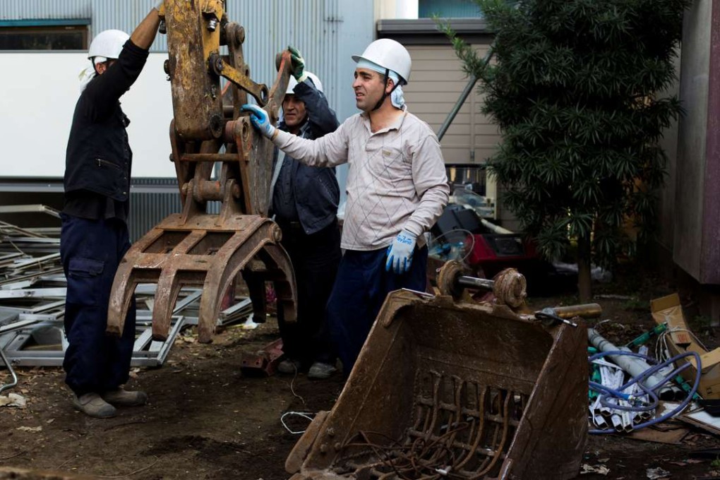 Kurdish men work at a demolition site in Chiba east of Tokyo. Many others work on highways and other public projects. Photo: Reuters