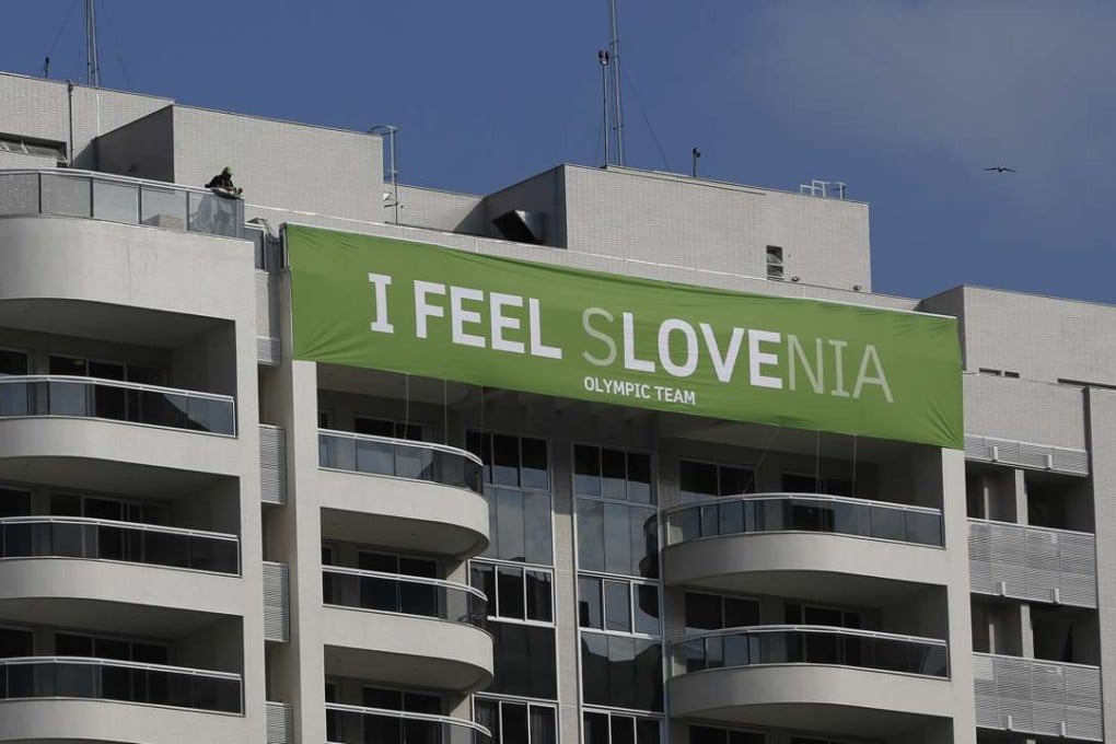 A banner of the Slovenia team hangs on the top of a building of the Olympic Village, where many athletes are said to be ‘feeling the love’ thanks to mobile dating apps. Photo: AP