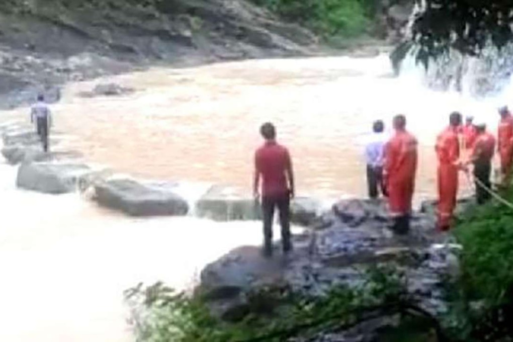 Rescue workers search for two tourists who were swept away by a flash flood. Photo: SCMP Pictures