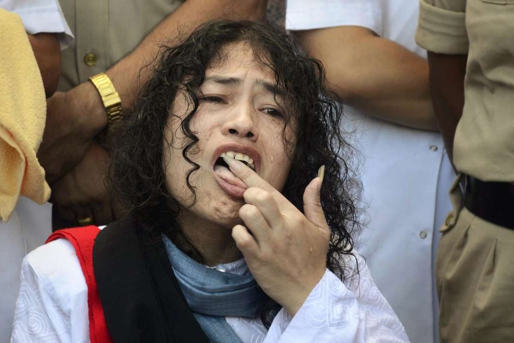 Indian political activist Irom Sharmila licks honey from her hand to break her fast in Imphal, north-eastern Indian state of Manipur, India, Tuesday, August 9. Photo: AP