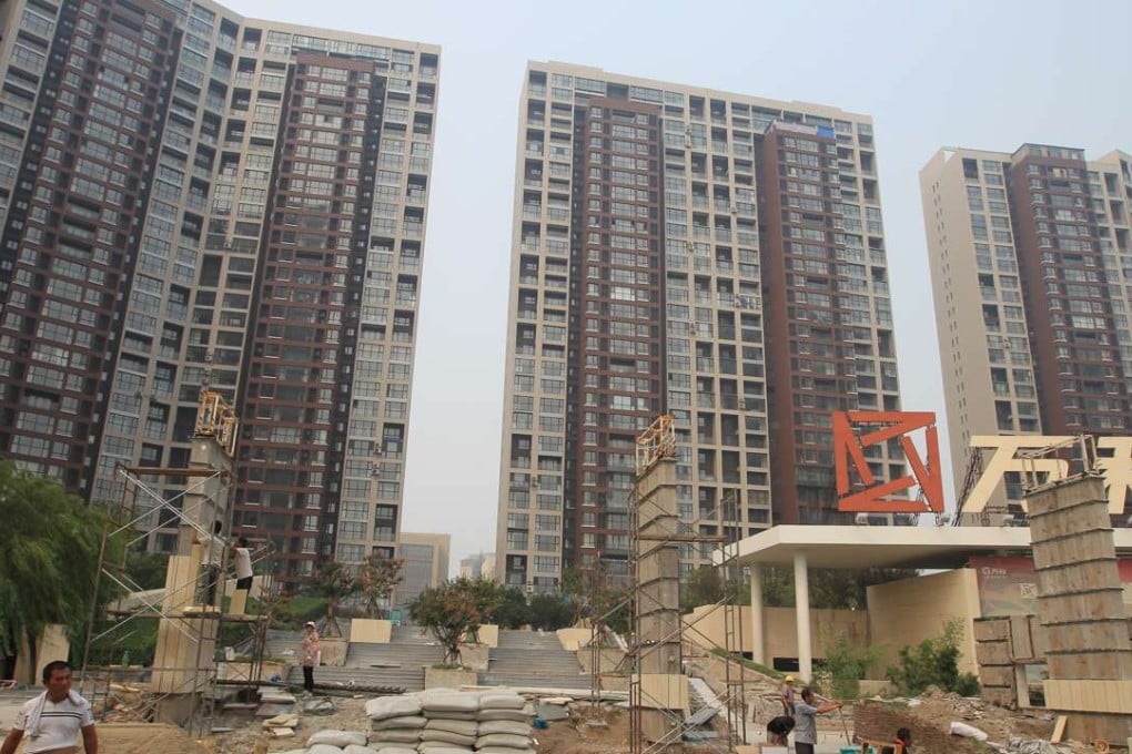 The entrance to a residential area is under renovation in Tianjin a year after the blasts. Many windows in these buildings were damaged in last year's explosions. Photo: Simon Song
