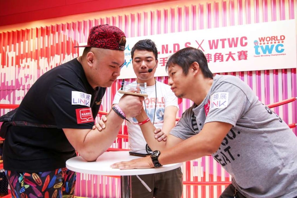 Local participants battling in the semi-finals of the World Thumb Wrestling Championships in Hong Kong. Photo: SCMP Pictures