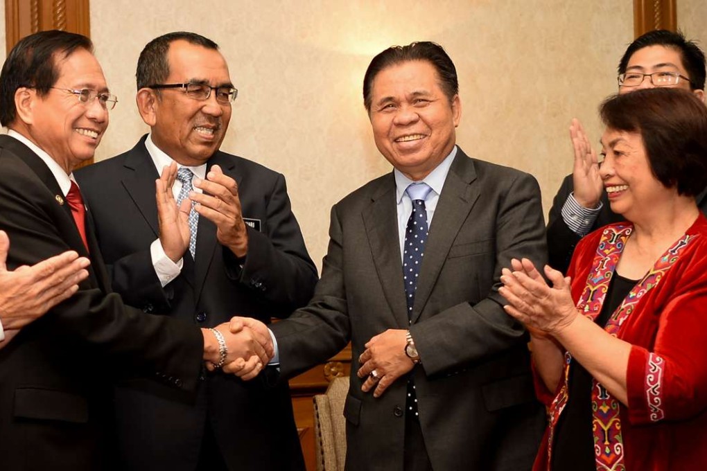 Philippine presidential adviser on the peace process Jesus Dureza (left) shakes hands with Murad Ibrahim (centre), chairman of the southern Philippine rebel group Moro Islamic Liberation Front (MILF) prior to their meeting on peace talks in Kuala Lumpur on August 13, 2016. Photo: AFP