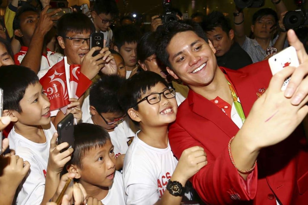 Singaporean swimmer Joseph Schooling poses for a selfie as he arrives in Singapore after his heroics in Rio. Photo: AP