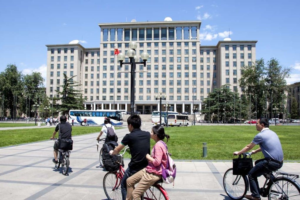 Students cycle past the central main building on campus at Tsinghua University in Beijing. Photo: SCMP Pictures