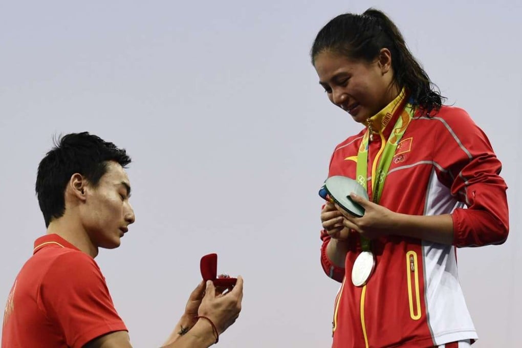 Silver medallist He Zi of China reacts after she receives a marriage proposal from Chinese diver Qin Kai during the podium ceremony for the women’s diving 3m springboard in Rio. Photo: AFP