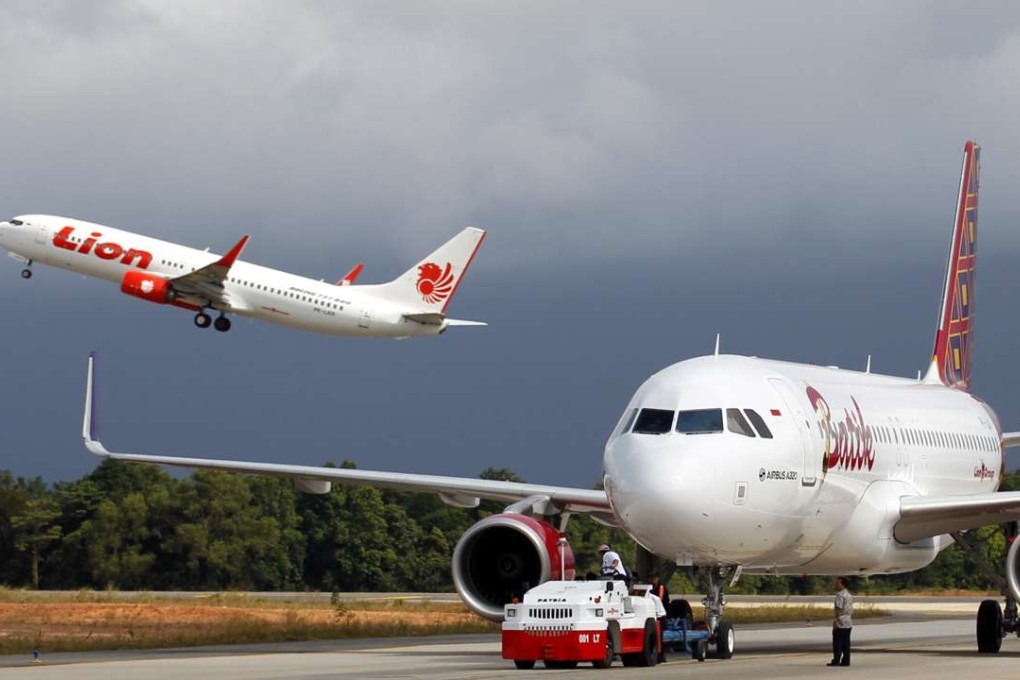 A Lion Air jet takes off as a Batik Airline plane is manoeuvred on a runway at Hang Nadim International Airport in Batam, Riau, Indonesia. Photo: EPA