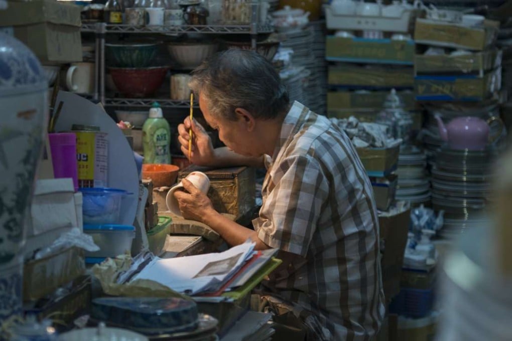 A craftsman paints porcelain at Yuet Tung China Works. Photos: Antony Dickson.