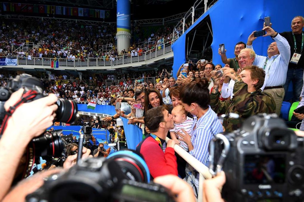 Michael Phelps kisses his son Boomer after winning the men's 200m butterfly final. Photo: EPA