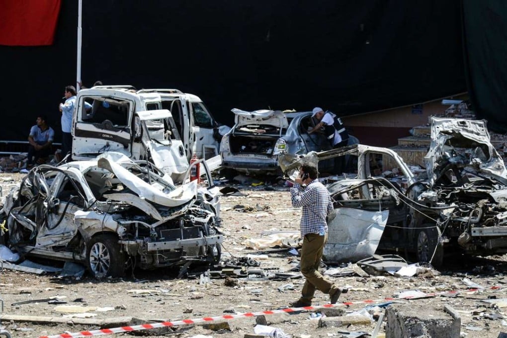 A man walks among the wreckage of vehicles as Turkish rescue workers and police inspect the blast scene in the eastern city of Elazig. Photo: AFP