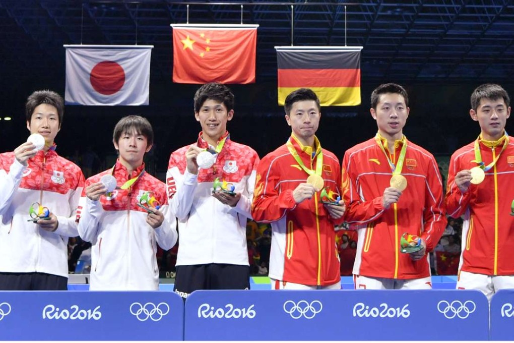 China’s triumphant table tennis team, (from R) Zhang Jike, Xu Xin and Ma Long, pose with their gold medals after defeating Japan in the final. Photo: Kyodo