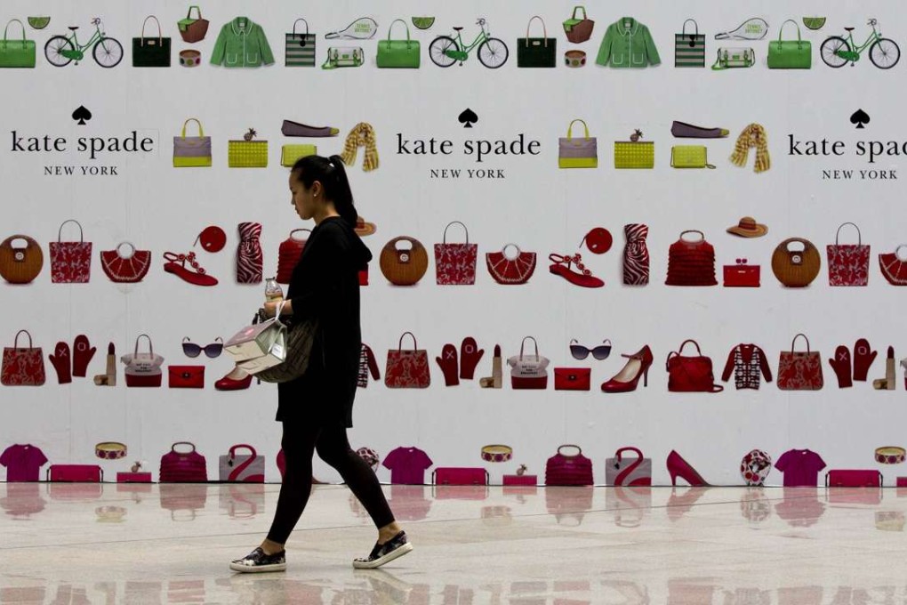 A shopper walks past a boutique outlet under construction covered by its advertisement board at a shopping mall in Beijing. Chinese retail spending is being tipped to overtake the US this year. Photo: AP