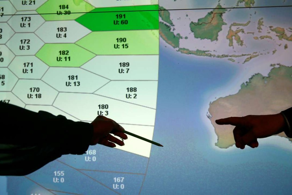 Member of staff at satellite communications company Inmarsat point to a section of the screen showing the southern Indian Ocean to the west of Australia, at their headquarters in London. Photo: Reuters